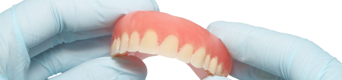 Dentist holding dentures